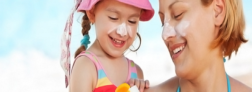 child with mother using sunscreen